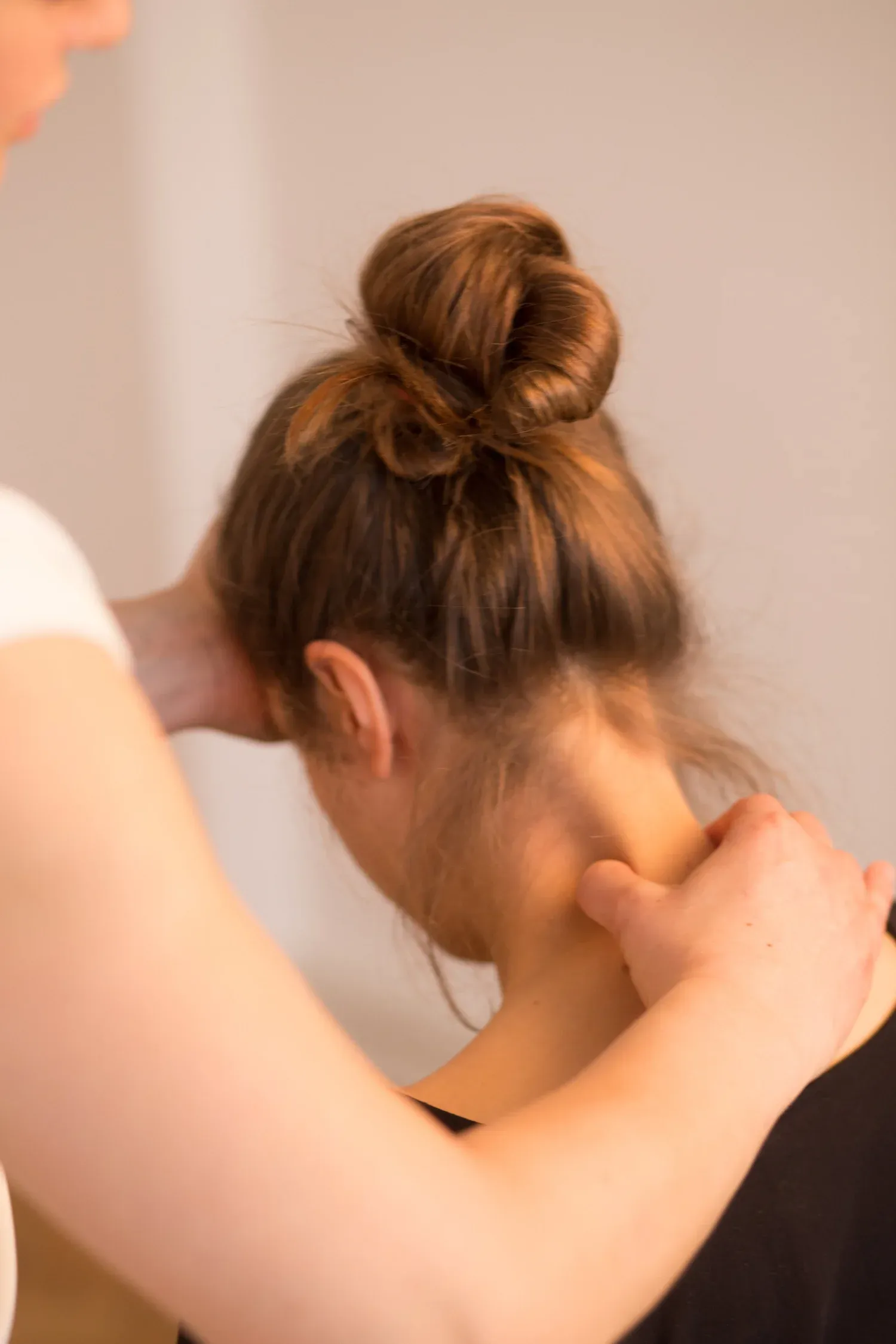 Körperarbeit in der Praxis: Rebekka Frank arbeitet mit beiden Händen am Nacken einer Klientin